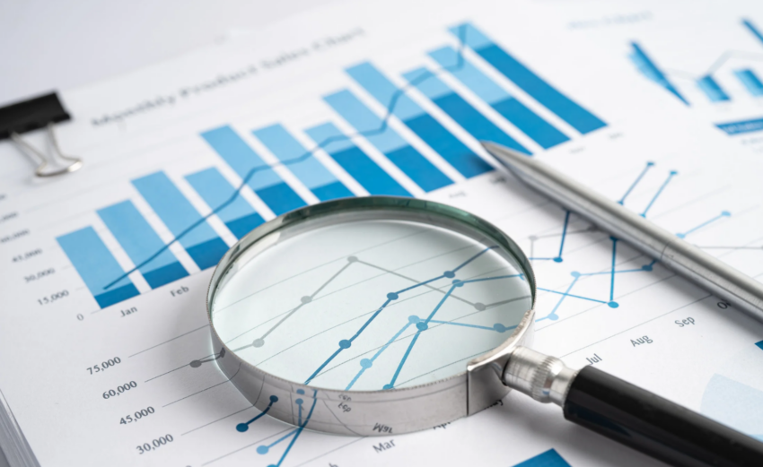 loupe pointant une ligne d'un tableau de bord imprimé, illustrant le choix des indicateurs non financiers à suivre
