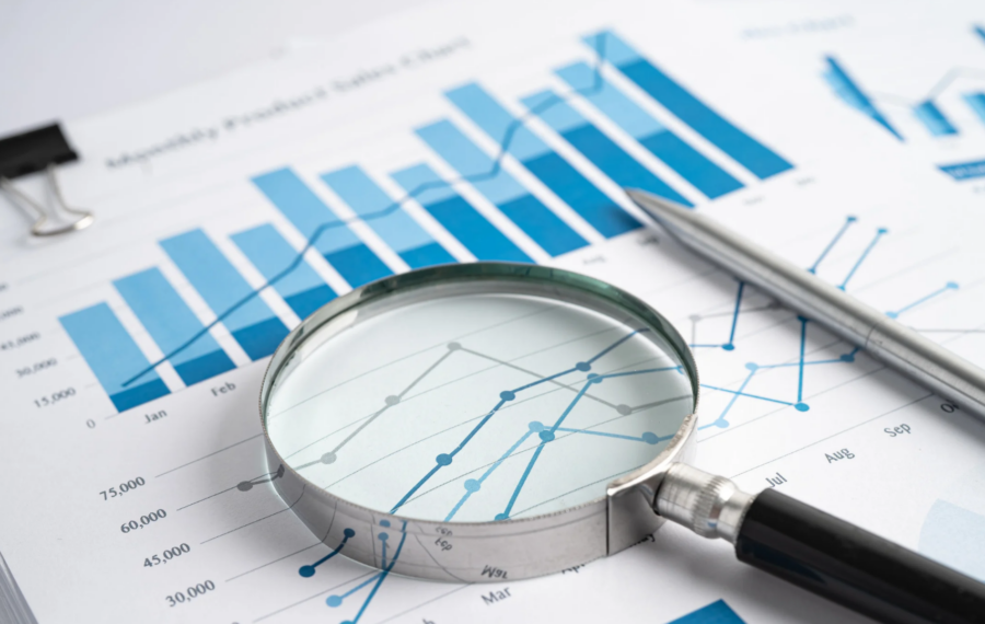 loupe pointant une ligne d'un tableau de bord imprimé, illustrant le choix des indicateurs non financiers à suivre